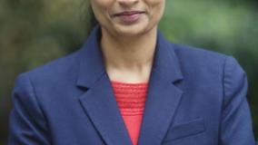 Indian woman in blue blazer with red shirt underneath