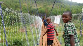 Kids crossing a footbridge in Rwanda
