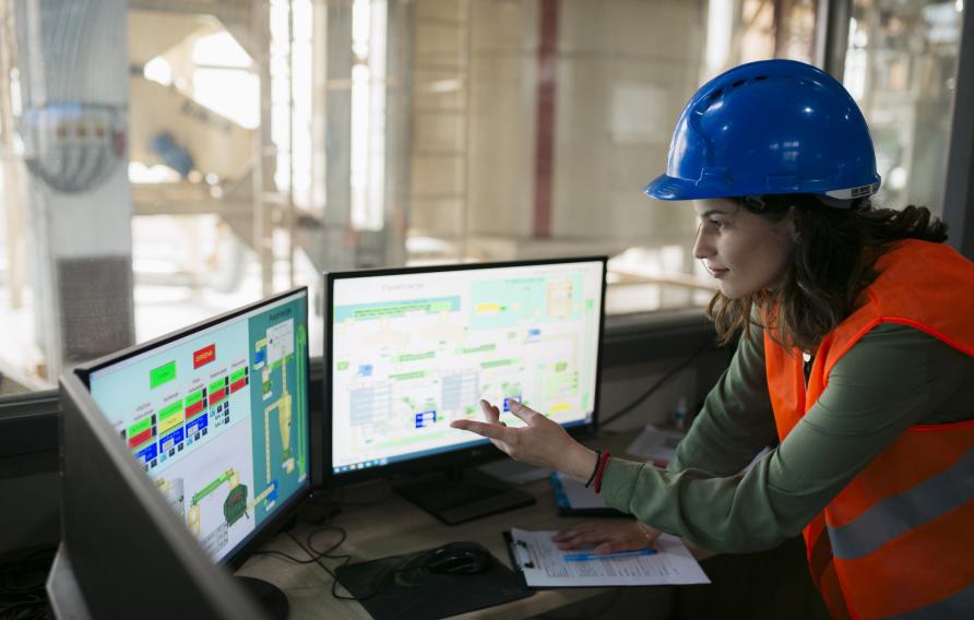 Women in PPE looking at computer screens