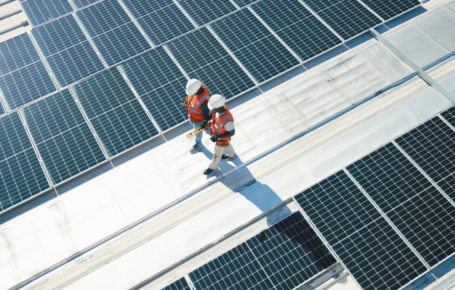 Renewable energy, solar panels and team walking on roof planning for inspection at sustainable business. Engineering, sustainability and photovoltaic power on rooftop, men in electricity maintenance.