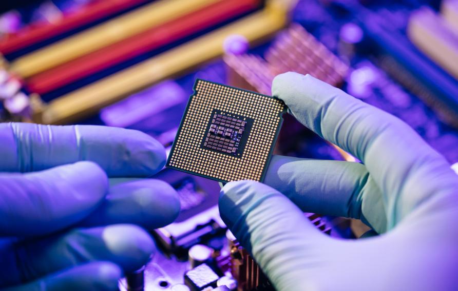 Laboratory technician holds a powerful processor in his hands. CPU computer processor shallow focus. CPU socket of the computer's motherboard. Concept of computer, motherboard, hardware and technology