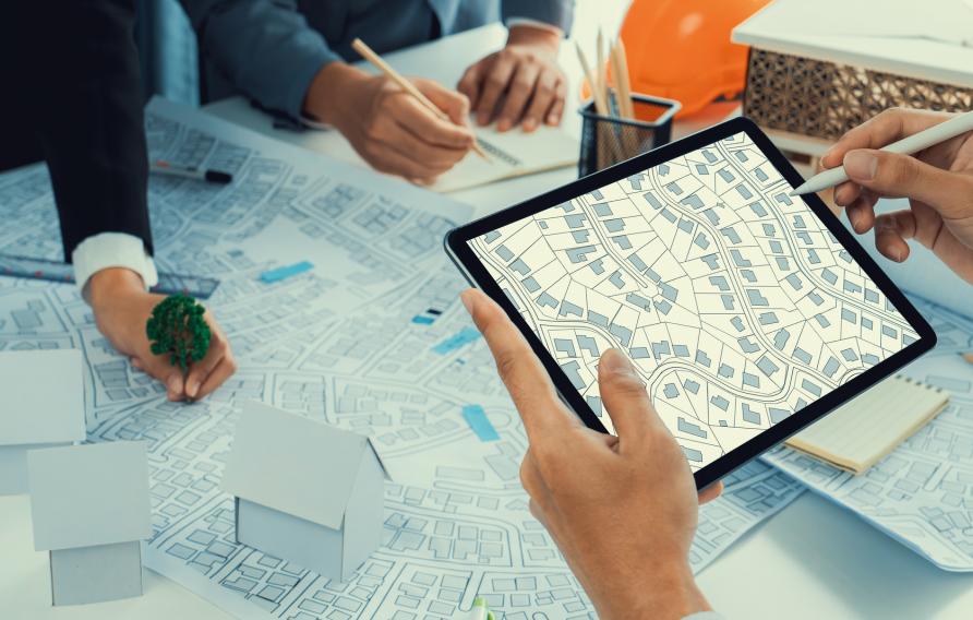 Worker, architect and engineer work on real estate construction project oratory planning with cartography and cadastral map of urban town area to guide to construction developer business plan of city