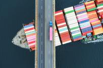 Shipping container sailing under a bridge