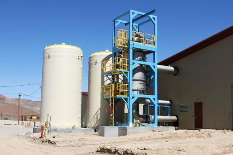 White vertical tanks next to blue scaffolding