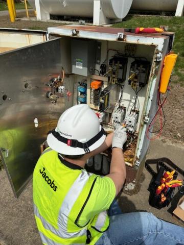 Jacobs team member in PPE repairs a sewage pump