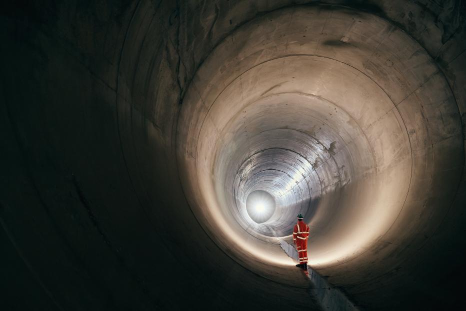 Worker standing in a sewer tunnel before operation.