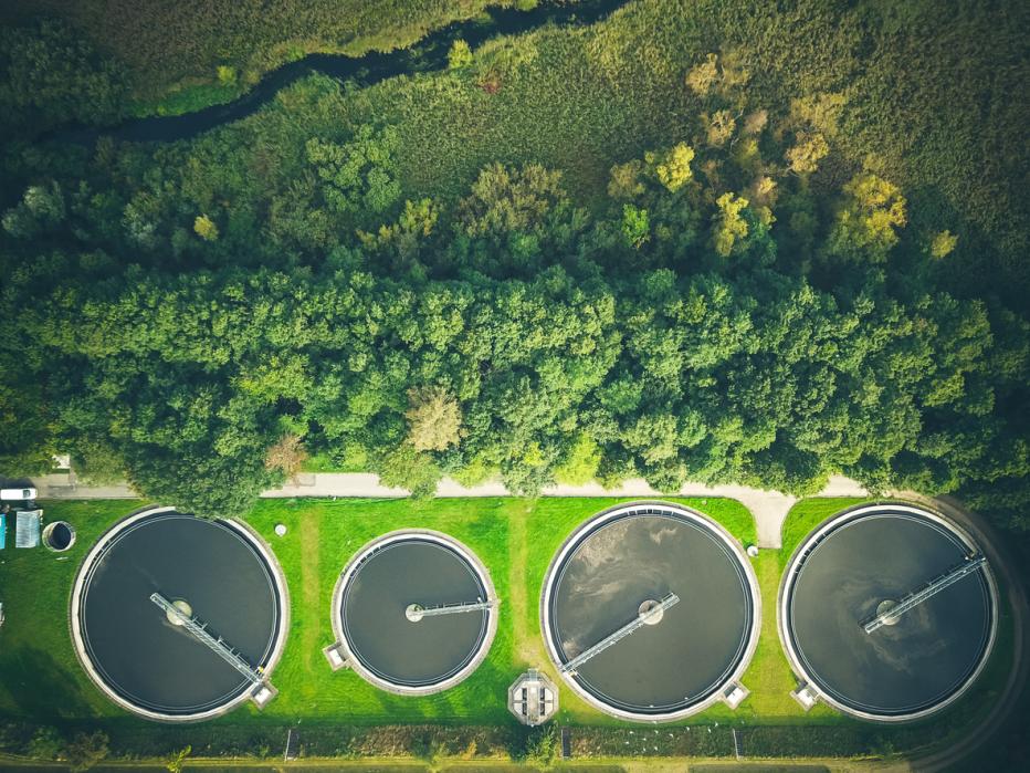 Aerial shot of sewage treatment plant placed near a river, Denmark. Aerial view shot with drone.