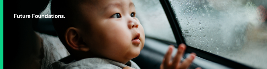 Asian child looking out rainy window of vehicle