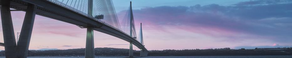 A view of a large three-tower cable-stayed bridge at sunrise. Queensferry Crossing Bridge, Scotland, United Kingdom