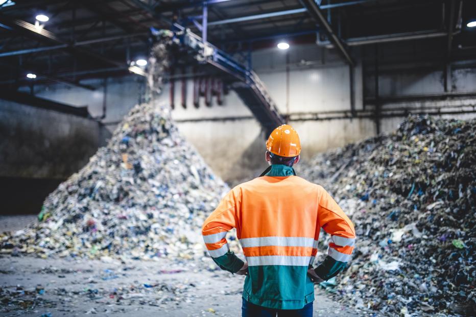 Person looking a pile of recycling