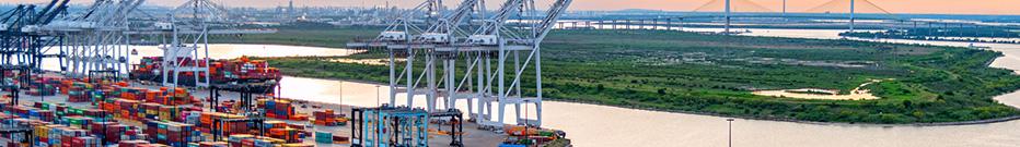 A large container ship being unloaded at the port of Houston, Texas, Morgan's Point, shot via helicopter at sunset from an altitude of about 400 feet.