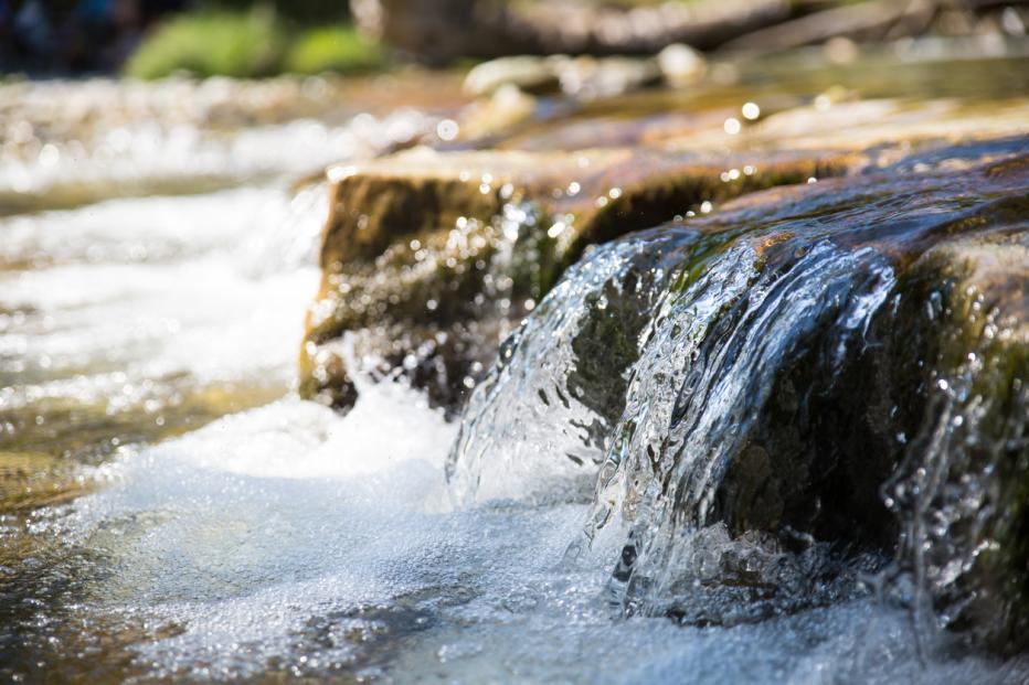 Water running over a rock in a river