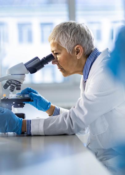 Chemist working on a microscope in laboratory